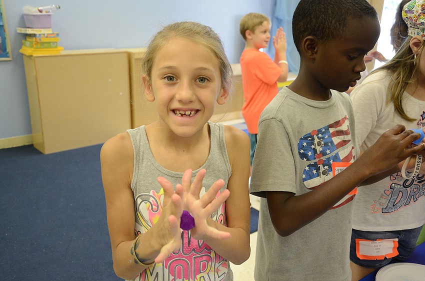 Ava Thompson, 8, smooths out the bouncy ball she made.