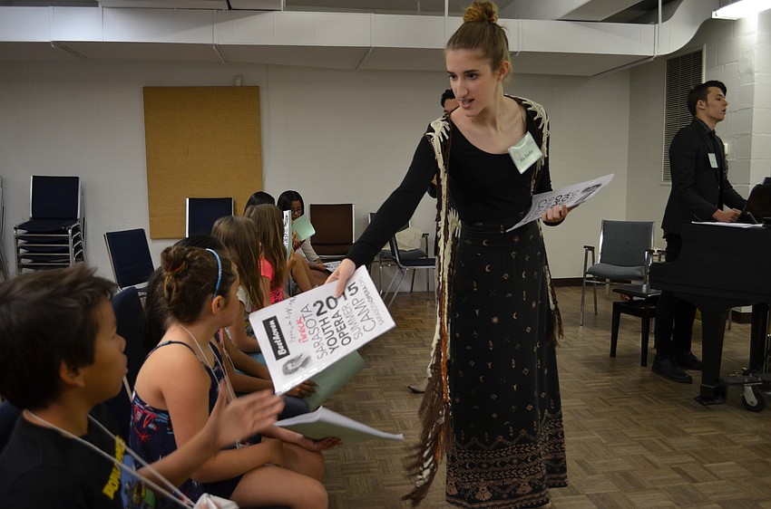 Teacher assistants hand out music to the students.