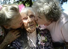 Edna Strode gets a kiss from her two daughters, Betty Hollifield and Wilma Ellison.