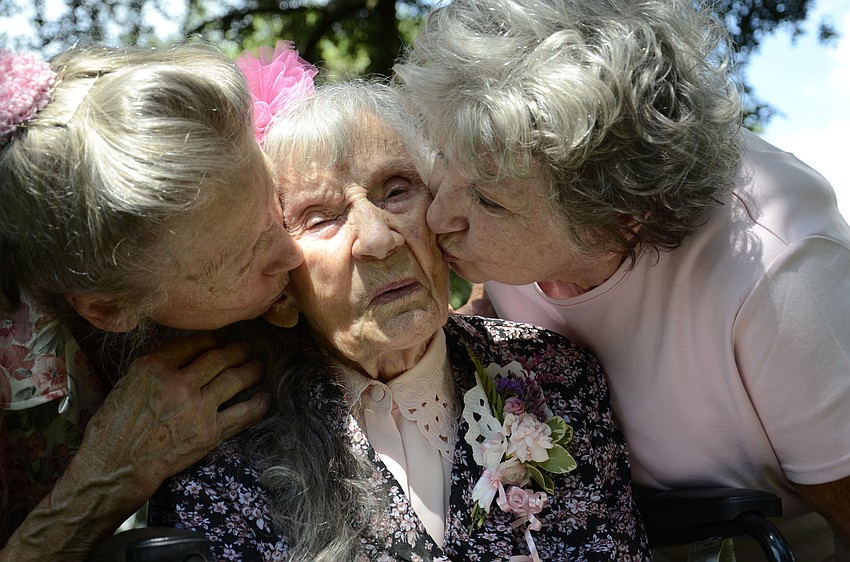 Edna Strode gets a kiss from her two daughters, Betty Hollifield and Wilma Ellison.