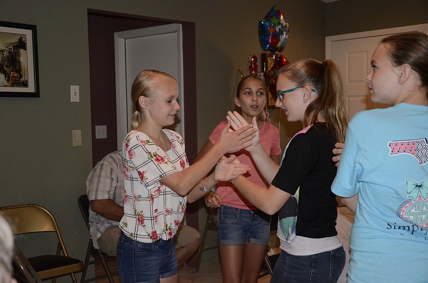 Hannah Hollifield and cousin Kyndal Corkins play handgames at their great-great grandmother's 100-year party.
