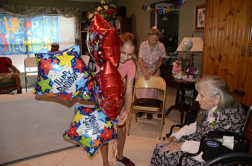 Mallory Shirey brings in birthday balloons to Edna Strode.