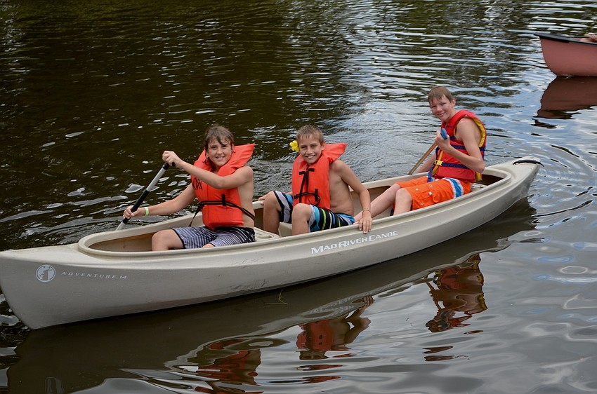 Jakin Wilson, Thomas King and Isaiah Lovelace maneuver down the pond located at the back of the church's property.
