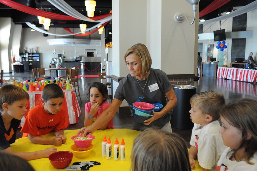 Pam Carroll hands out jewels for the children to decorate their hats.