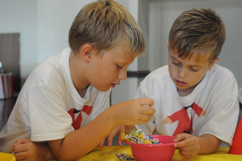Logan Wilch, 7, and Luke Rodman, 6, pick out decorations for their party hats.