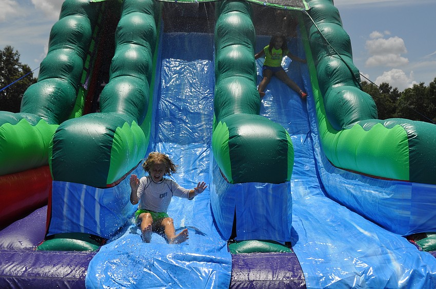 Calli Phillips, 9, and Helena Dunham, 8, race down the water slide during water day.