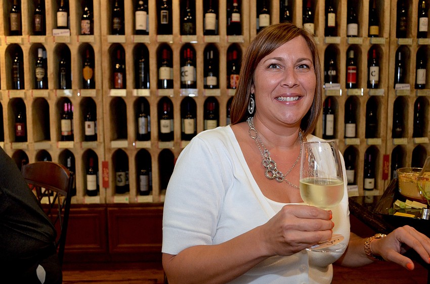 Jen Lonero prefers white wine while checking her bingo board.