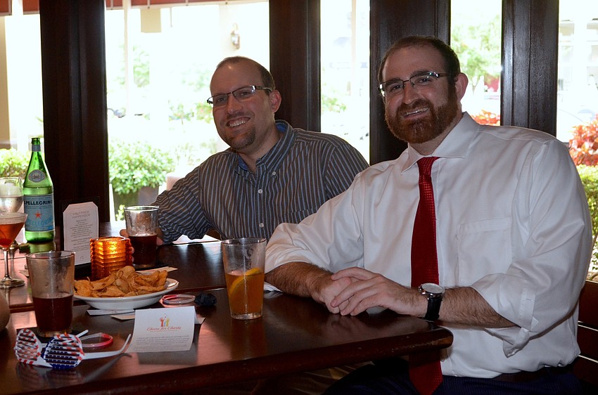 Brett Lowe and Josh Wertheim share appetizers and enjoy cold beers.