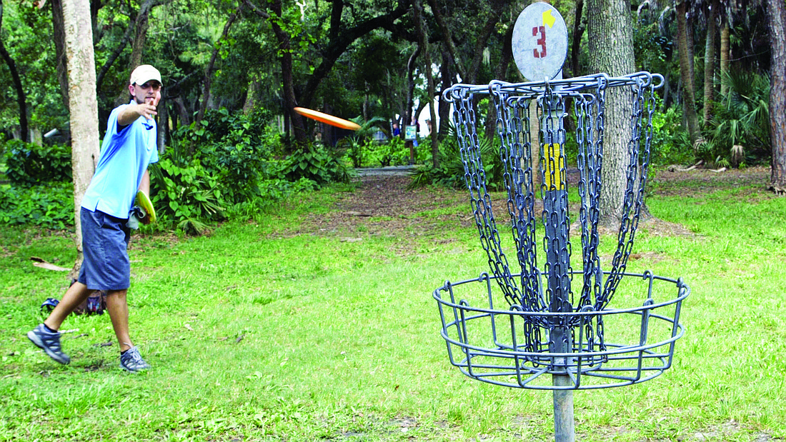 Professional disc golf player Bryan Moore putts on the third hole of the disc-golf course located within North Water Tower Park. Photo by Alex Mahadevan