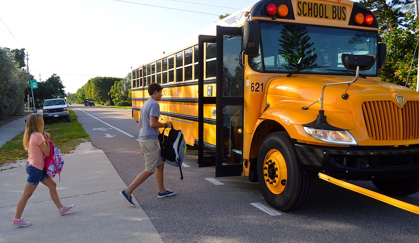 Ciarra Buff, a sixth-grader, and Joseph Peery, an eighth-grader,  board the bus for their first day of classes at Martha B. King Middle School. Asked if he was excited for school to start, Peery said, 