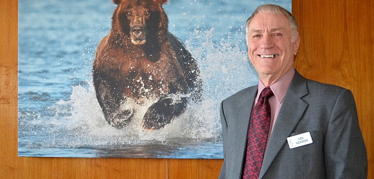 Lou Newman with one of this many photographs featured at Plymouth Harborâ€™s Mezzanine Art Gallery.