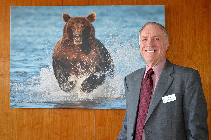 Lou Newman with one of this many photographs featured at Plymouth Harborâ€™s Mezzanine Art Gallery.
