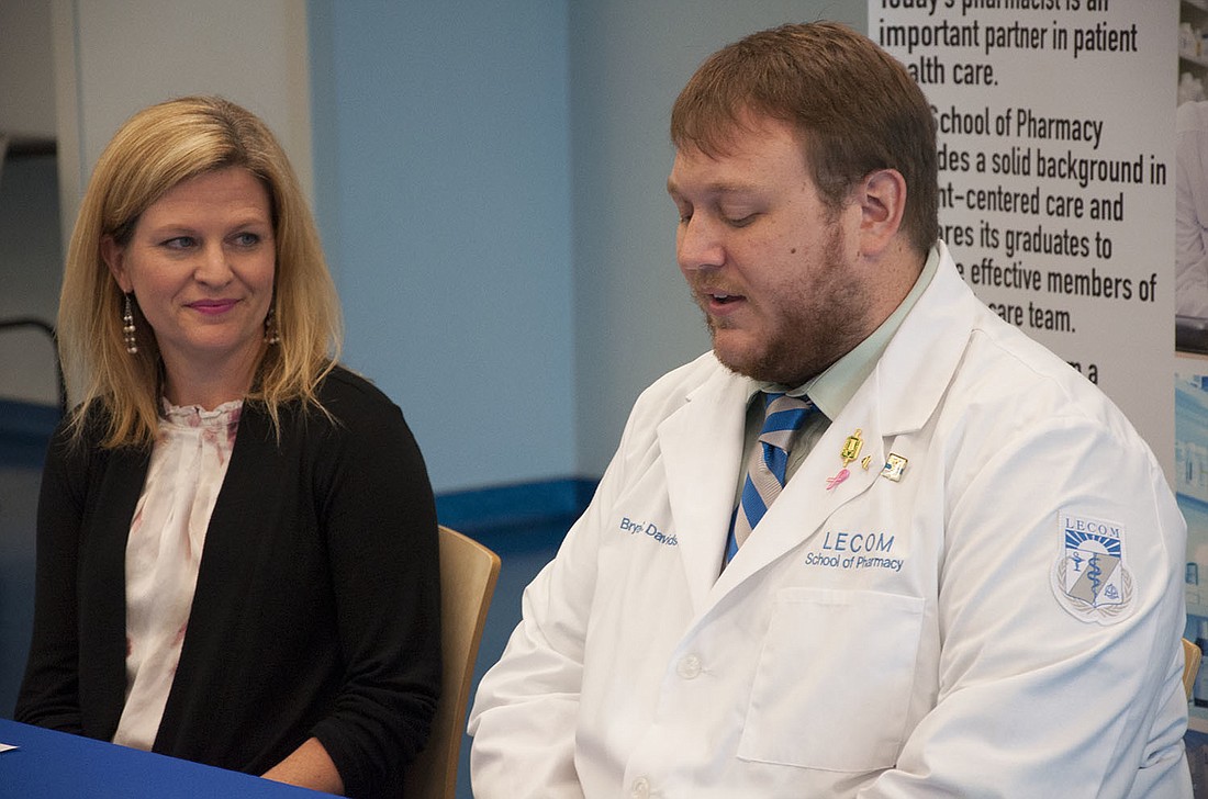 LECOM School of Pharmacy Associate Dean Dr. Julie Wilkinson, watches as third-year student Bryan Davidson announces LECOM's national awards for the Script Your Future campaign.