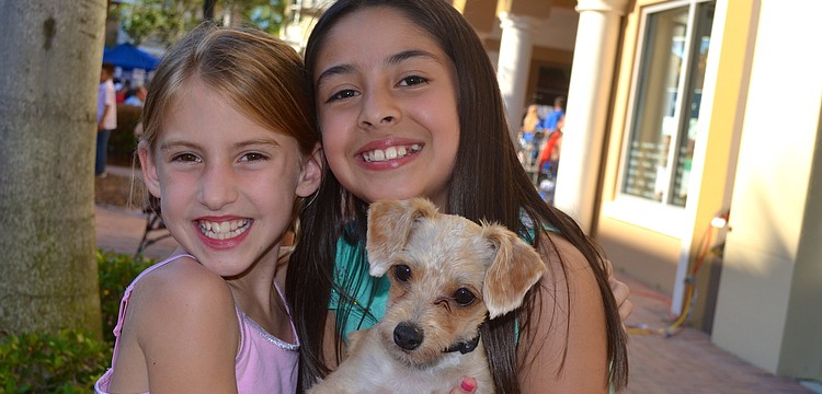 Rachel Small and Valeria Erazo say "cheese" beside their furry friend, Biscuit.