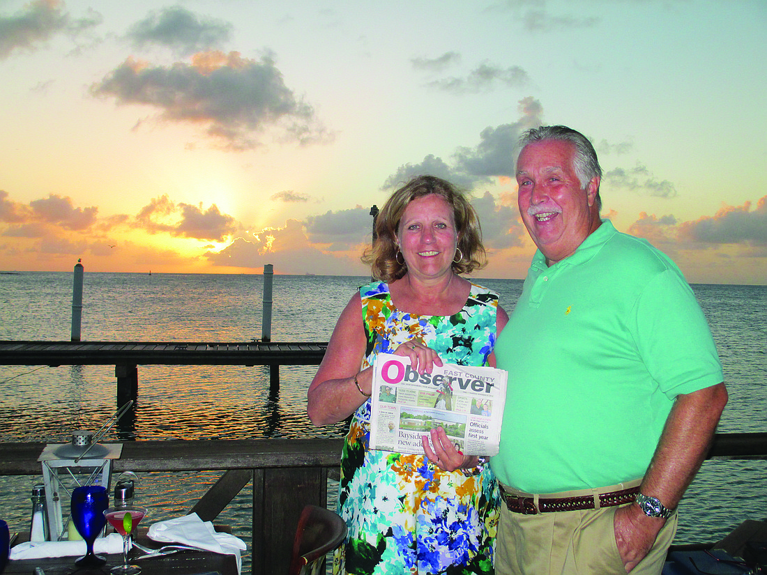 HAPPY PLACE. East County residents Monica and Richard Rice read their East County Observer while enjoying a sunset dinner in the Caribbean. The couple spent a week exploring Aruba and interacting with the people of "One Happy Island."