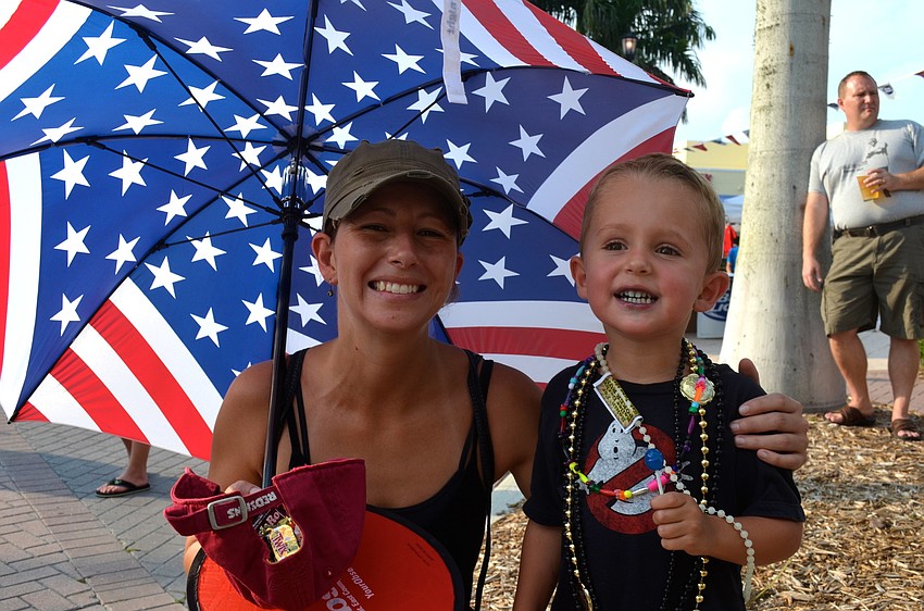 Jessica Radcliffe and her son, Wyatt, collect beads from parade participants.