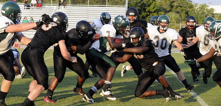Linebacker Jacari Dunbar and the Sailors defense wrap up St. Petersburg running back Jaquel Waller short of the goal line.