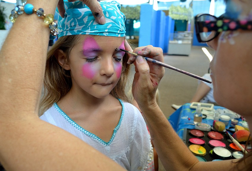 Isabella Savage, 5, gets her face painted by Suzy Kalin at the festival.