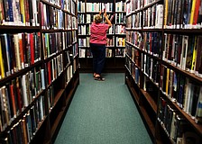 Carol Koplik shelves books on June 10, at the Longboat Library.