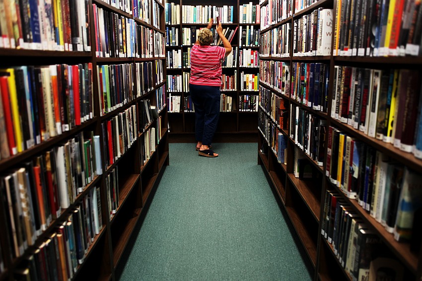 Carol Koplik shelves books on June 10, at the Longboat Library.