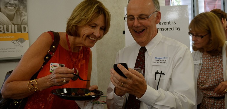 Ruth Anderson and Jeff Nickse look at photos.