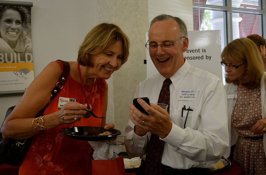 Ruth Anderson and Jeff Nickse look at photos.