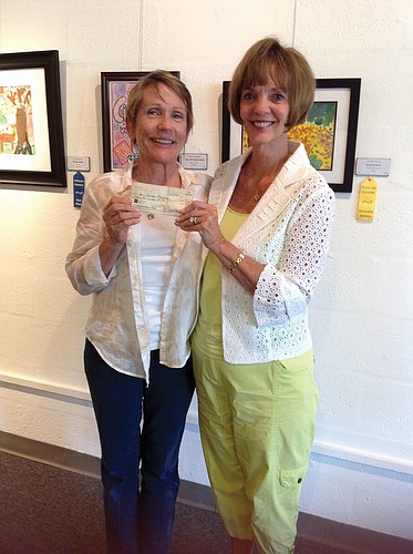 Carla Neirman, of Art Center Manatee, receives the check from Elaine Vaughn, with Creative Art Association