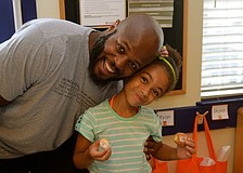 Monroe Racleful and his daughter, Delilah, snack on donuts.