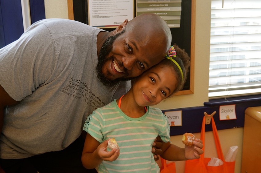 Monroe Racleful and his daughter, Delilah, snack on donuts.
