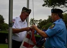 Roger DeWitt and John Raber, both members of Disabled American Veterans Chapter 18, prepare to raise the flag.