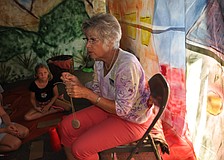 Jan Dahlstrom shows the children how to create a necklace from clay and string.