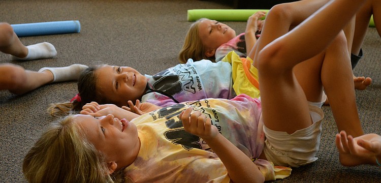 Seven-year-olds Madison Goda and Chiara Diaz get ready to kick a balloon.