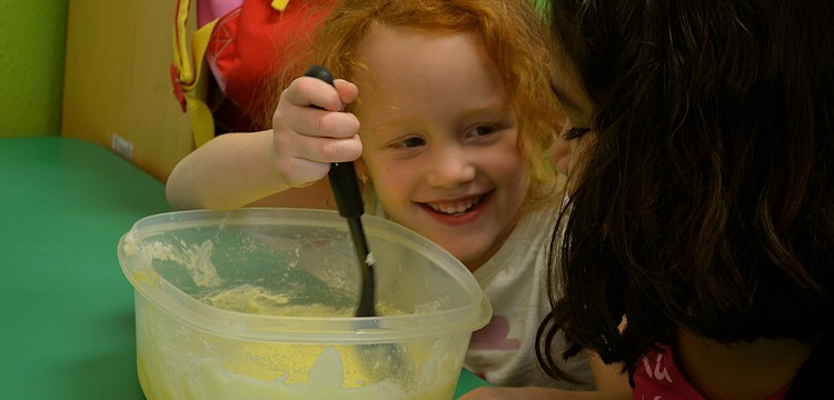 Storm Harris stirs the batter, while laughing with Xochitl Morales.