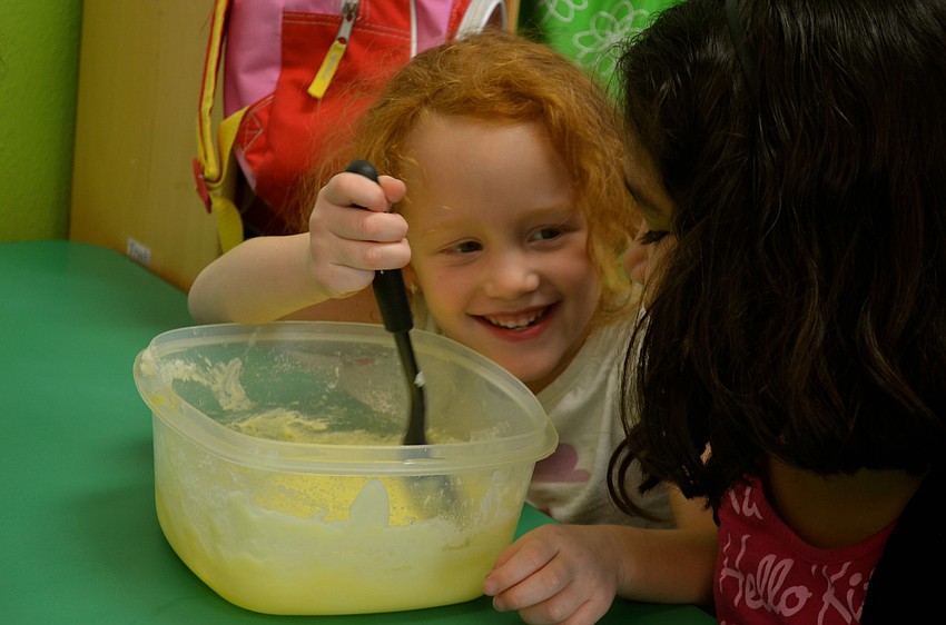 Storm Harris stirs the batter, while laughing with Xochitl Morales.