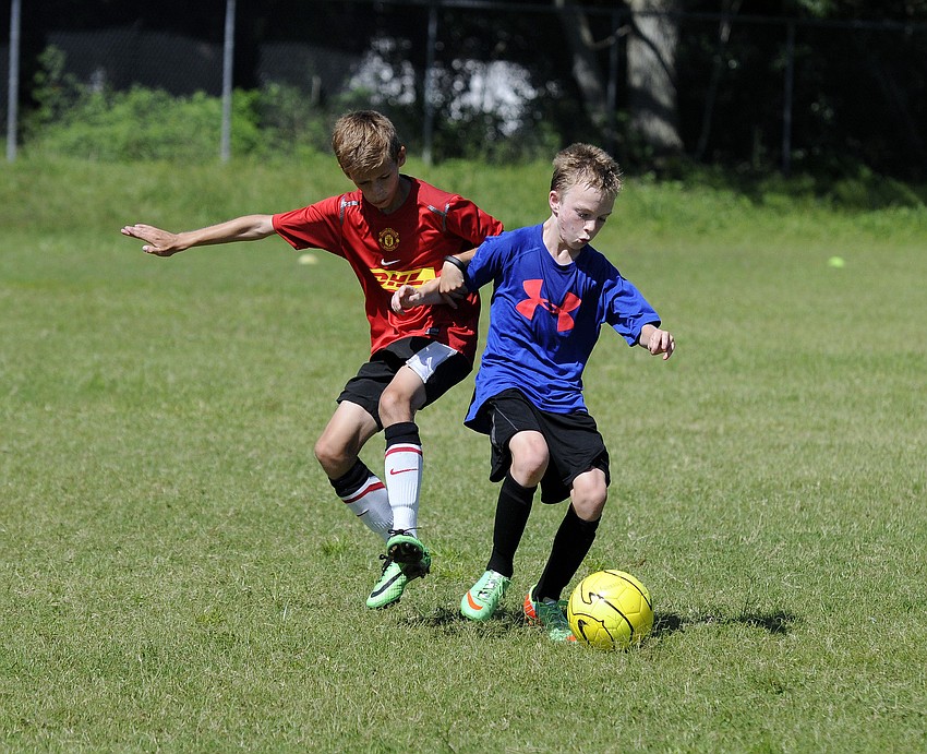 Calvin Drake, 12 and Owen Catlett, 12, battle for possession.