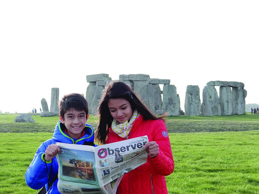 MONUMENTAL MOMENT. Alex Kumar, 12, and Madelyn Kumar, 15, catch up on their Observer news while visiting one of the worldâ€™s biggest mysteries â€” Stonehenge â€” in Wiltshire, England.