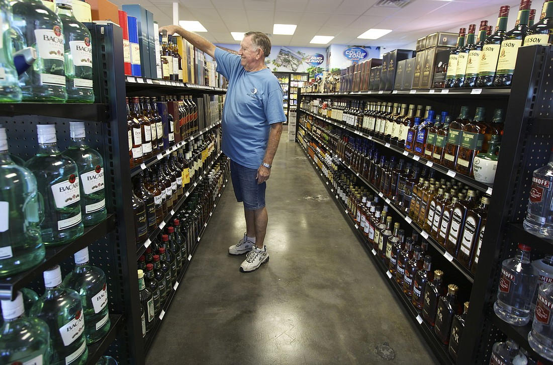 Photo by Kelsey Grau Jim Crawford helps stock whiskey and other liquors.