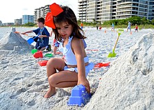 Caroline Moreno plays with sand on the beach.