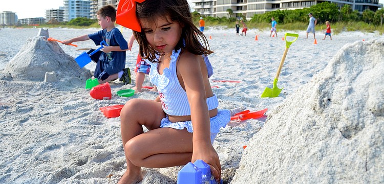Caroline Moreno plays with sand on the beach.