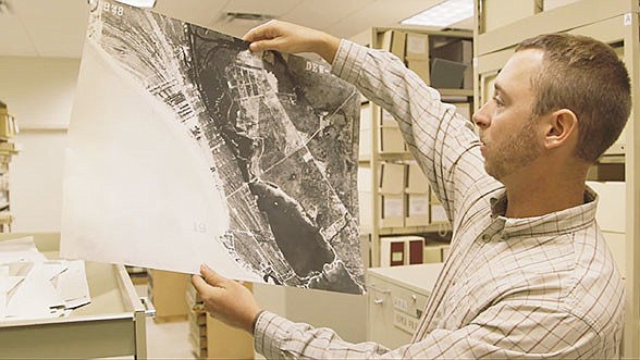 Sarasota County Archaeologist Ryan Murphy examines a historical aerial picture of the countyÃ¢â‚¬â„¢s barrier islands.