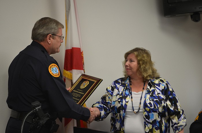 Longboat Key Police Chief Pete Cumming honors retired Detective Capt. Kris Roberts.