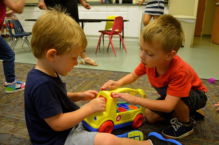 Camden Chalmers and Alex Cristeas play with cars.