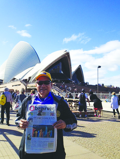 SOUND OFF. Lakewood Ranch resident Fred Lopez reads his East County news while enjoying the view of the Sydney Opera House, in Australia.