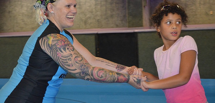 Christina â€œPinkyâ€ Williams helps Amelia Desha skate.