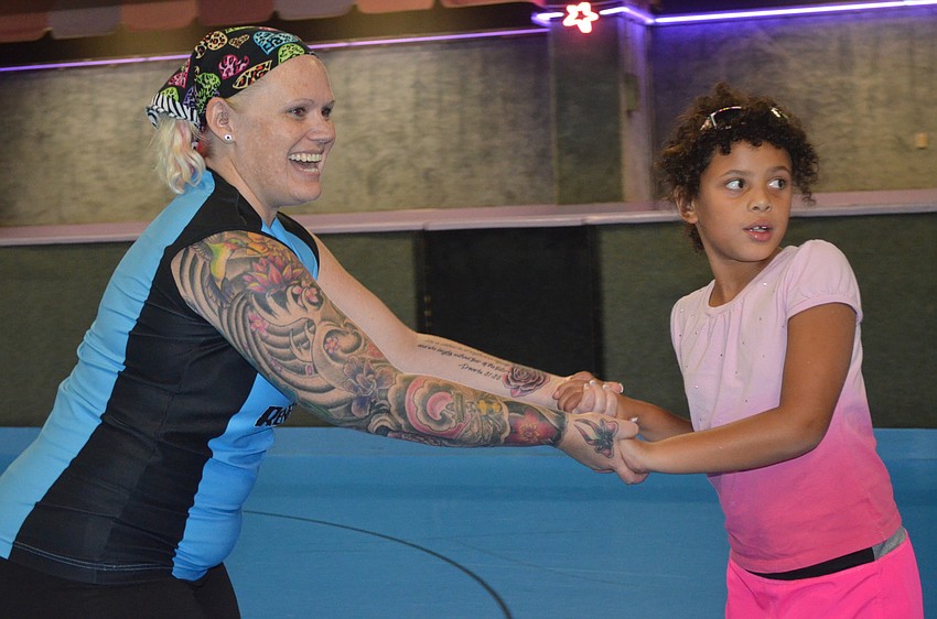 Christina â€œPinkyâ€ Williams helps Amelia Desha skate.