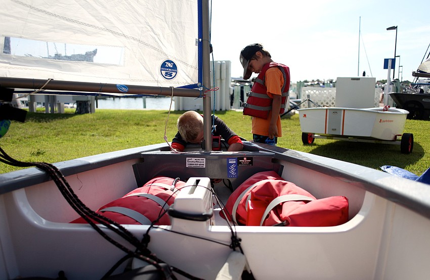 Jack Flovig, 8, prepares his optimist boat as Alex Berndt watches.