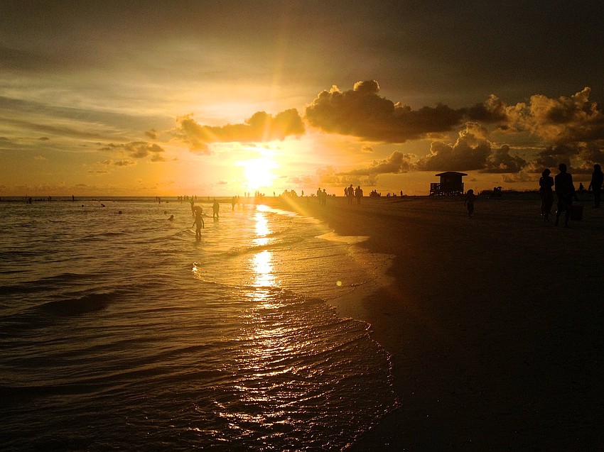 Storm clouds roll in as the sun sets on Lido Beach.