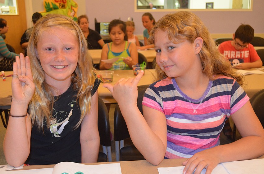 Lotus Bolan and Sabrina Benoit show â€œblueâ€ and  â€œyellowâ€ in American Sign Language.