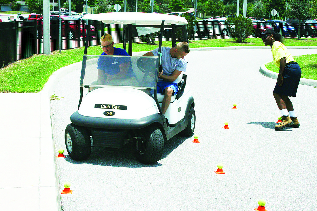 Courtesy Pine View Head Custodian Marcia Hill and driver Nikita Korsakov try to not hit the cones in Golf Cart Rodeo.