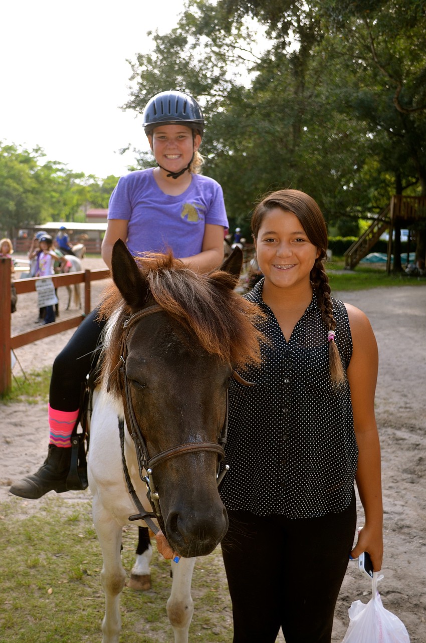 Jordan Podolak sits atop Zena, while Payton Ferris smiles nearby.